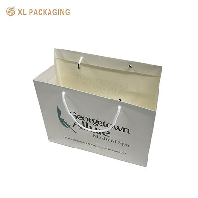 Custom printed paper shopping bags with water-resistant lamination and reinforced cotton rope handles for full brand display